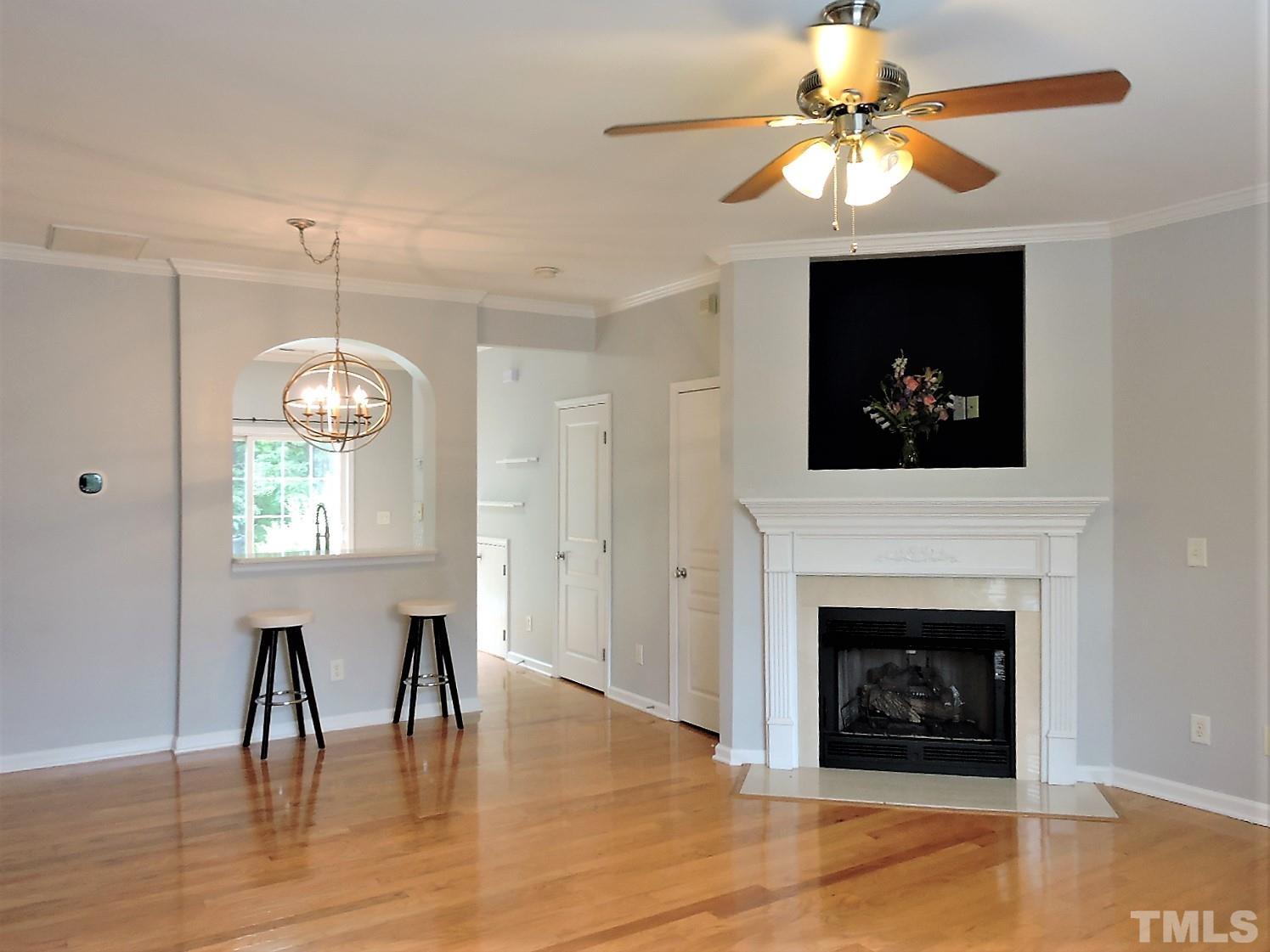 3811 Ramblewood Avenue Durham, NC 27713 - Photo 7 of 29 a view of a livingroom with a fireplace a chandelier and wooden floor