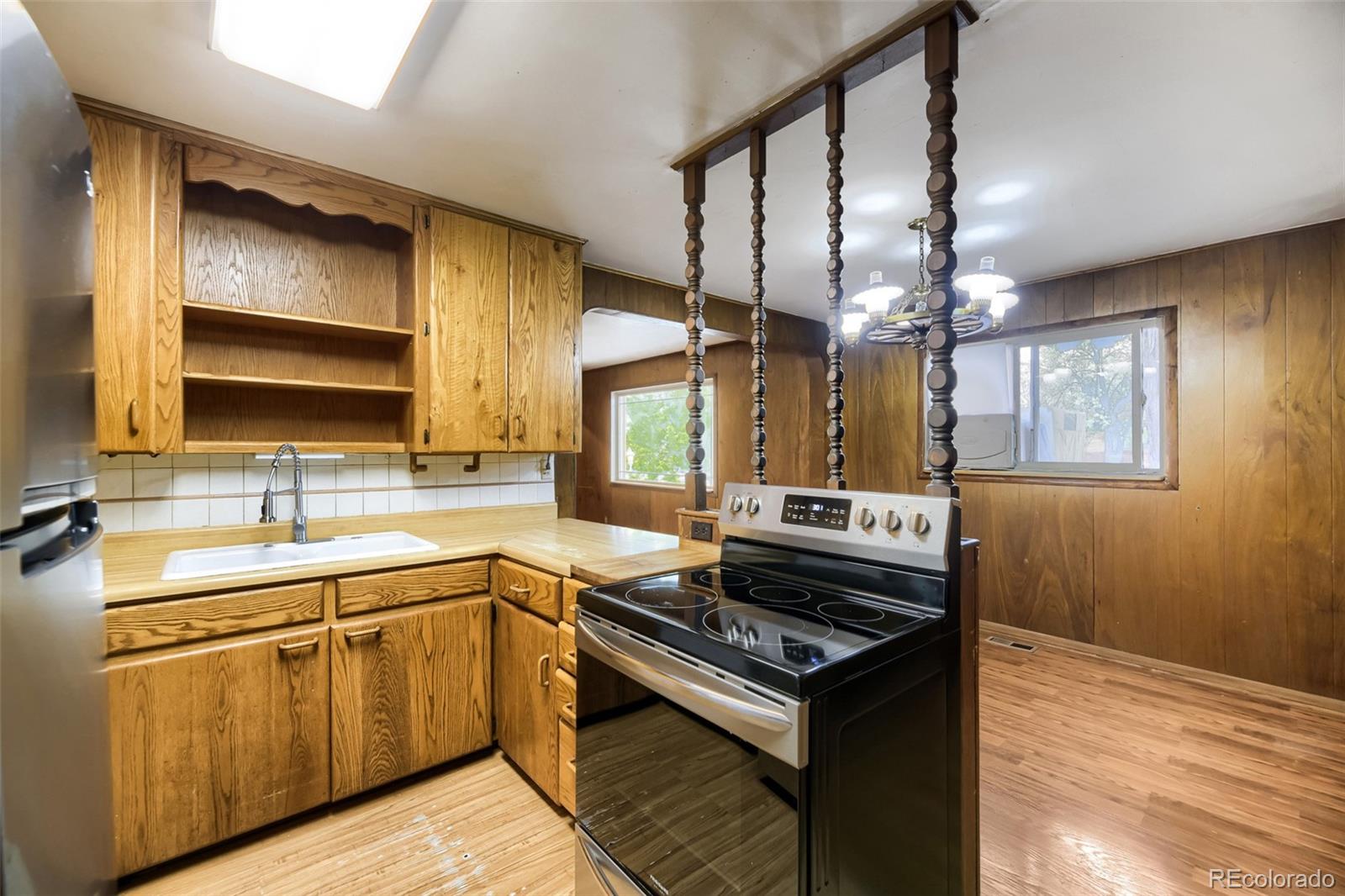 1521 Ruth Drive Thornton, CO 80229 - Photo 5 of 23 a kitchen with a stove a sink and a microwave