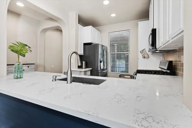 a kitchen with stainless steel appliances a sink stove and cabinets
