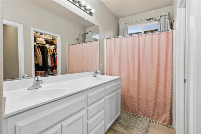 a bathroom with a double vanity sink and mirror