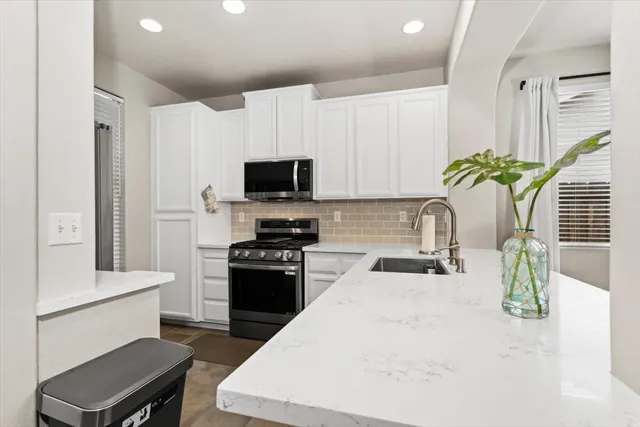 a kitchen with a stove a sink and a microwave