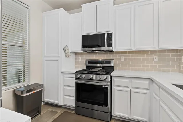 a kitchen with stainless steel appliances a stove a microwave sink and cabinets