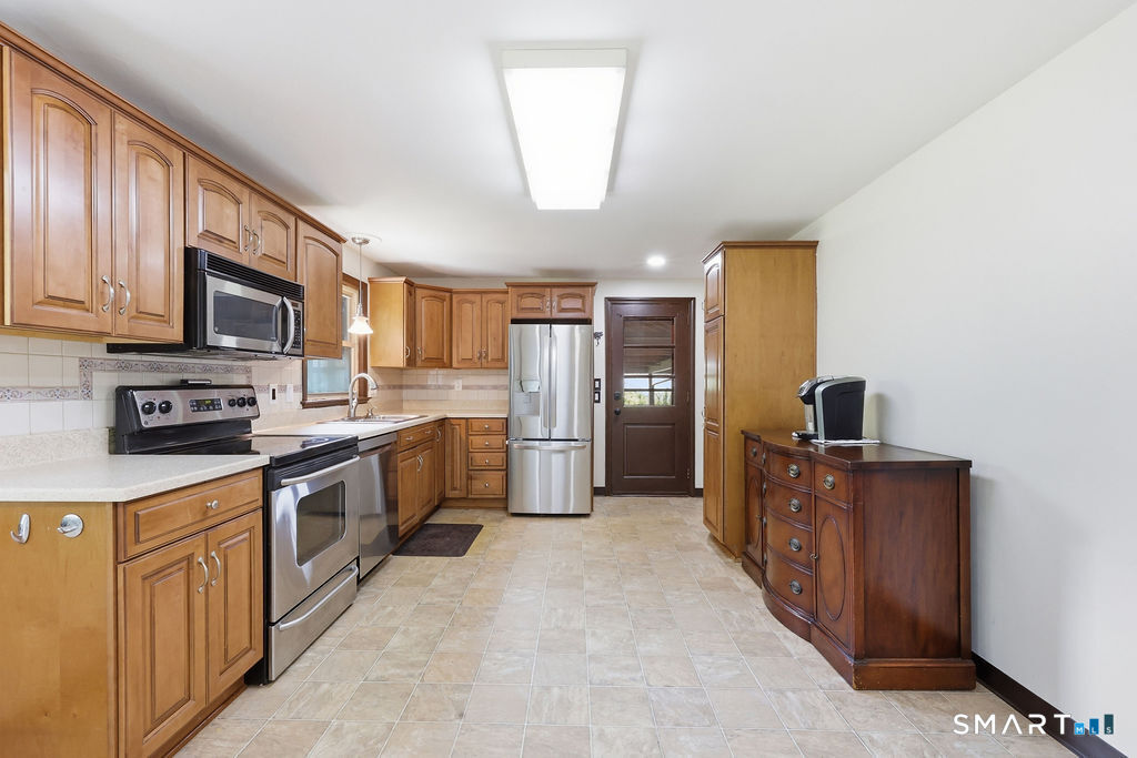 630 South Elm Street Wallingford, CT 06492 - Photo 6 of 30 a kitchen with stainless steel appliances granite countertop a stove refrigerator sink and a microwave