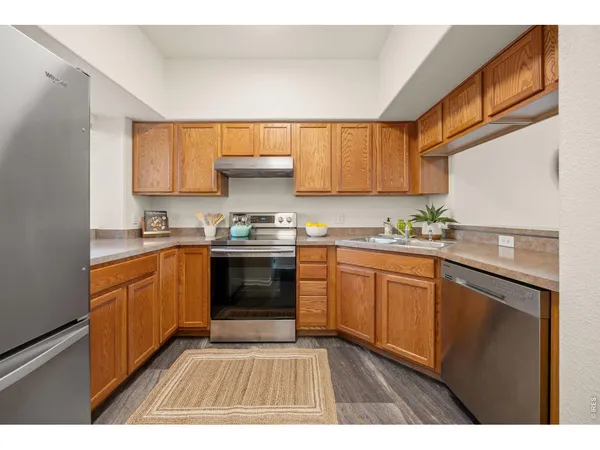 a kitchen with granite countertop stainless steel appliances a sink window and cabinets