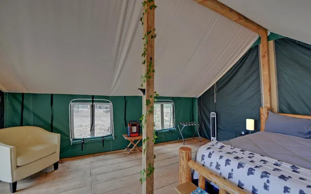 a bedroom with a bed and a dresser next to a window