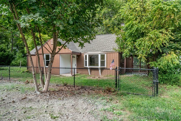 a backyard of a house with plants and large trees