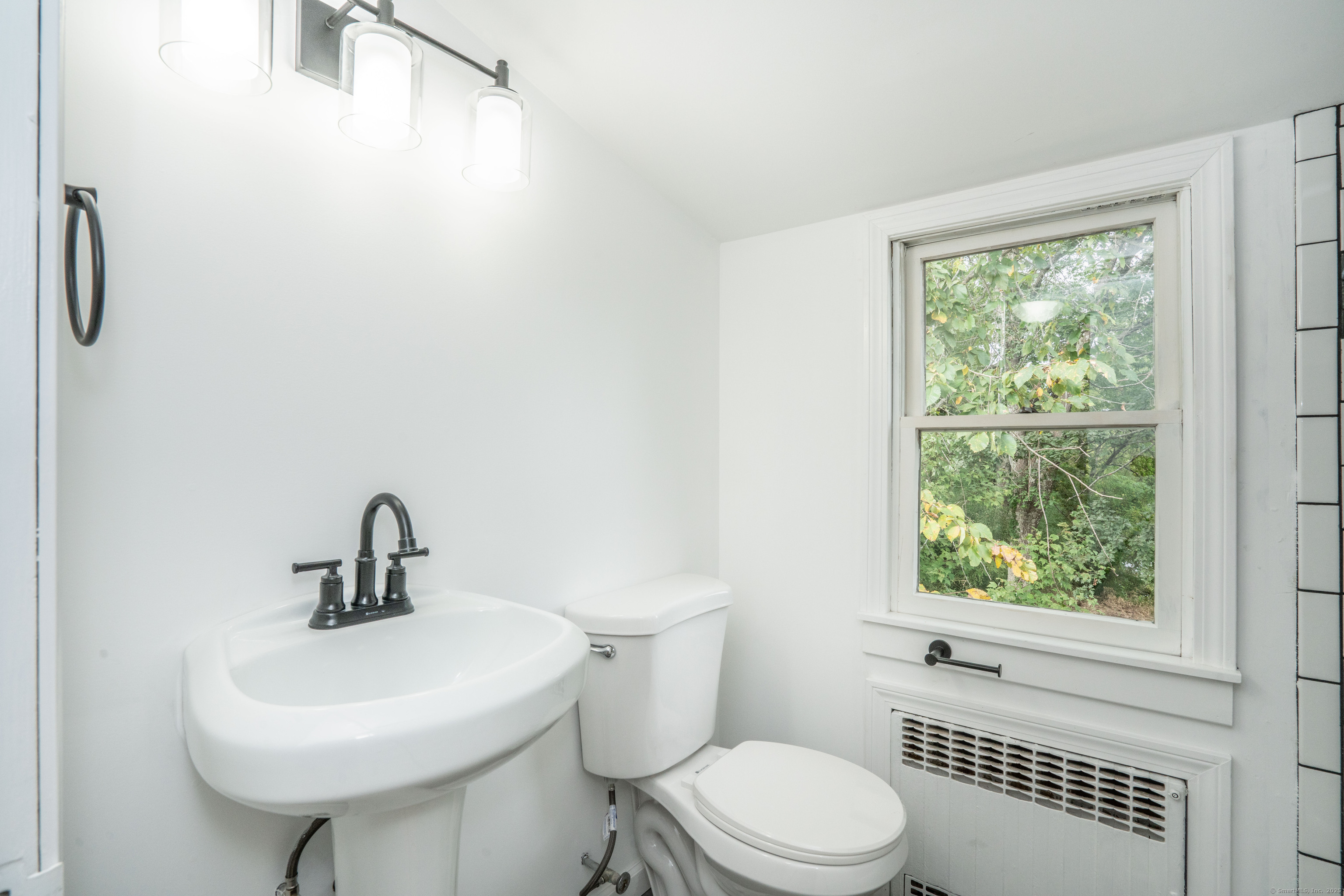 14 Main St Extension Simsbury, CT 06081 - Photo 25 of 39 a bathroom with a sink a toilet and a window