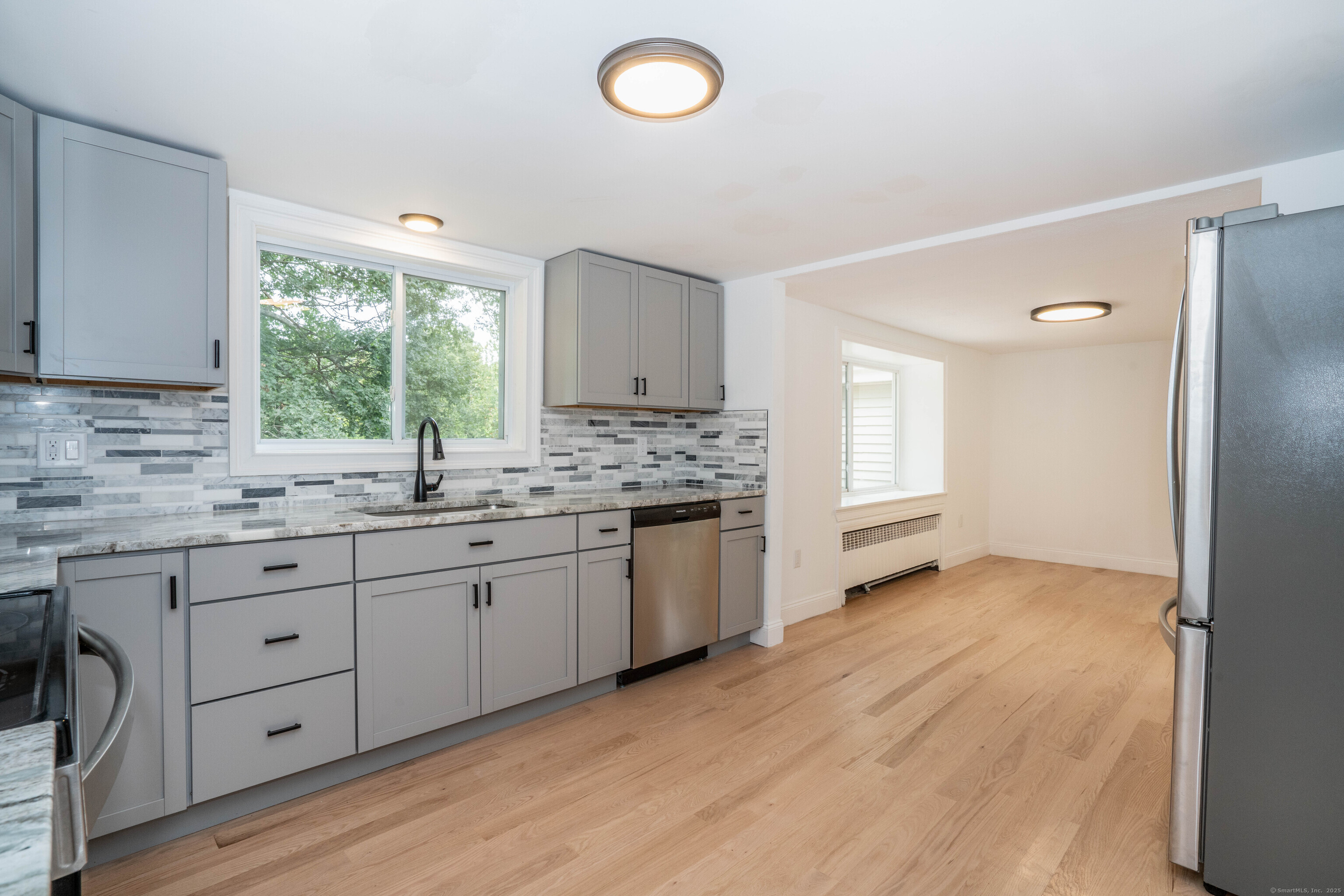 14 Main St Extension Simsbury, CT 06081 - Photo 4 of 39 a kitchen with granite countertop a sink cabinets stainless steel appliances and window