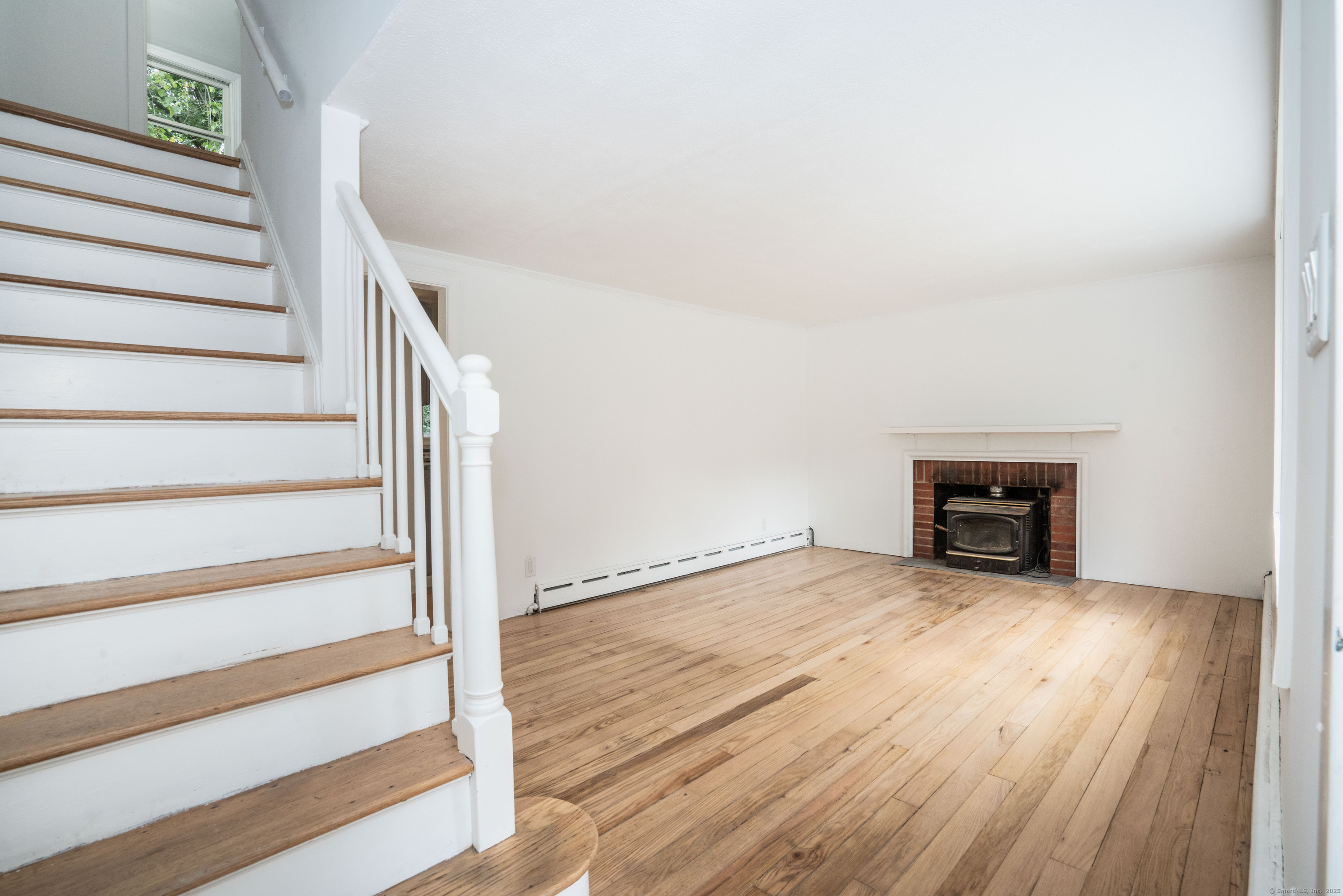 14 Main St Extension Simsbury, CT 06081 - Photo 9 of 39 a view of an empty room with wooden floor and stairs