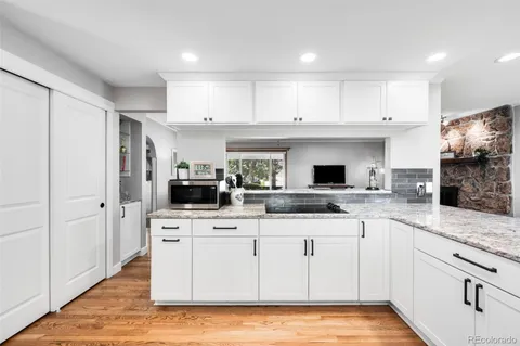 a kitchen with white cabinets sink and stainless steel appliances