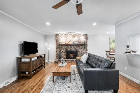 a living room with furniture a flat screen tv and a fireplace