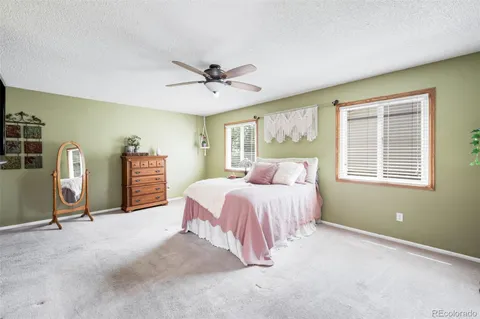 a spacious bedroom with a bed and dresser