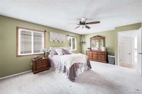 a spacious bedroom with a bed and dresser with mirror