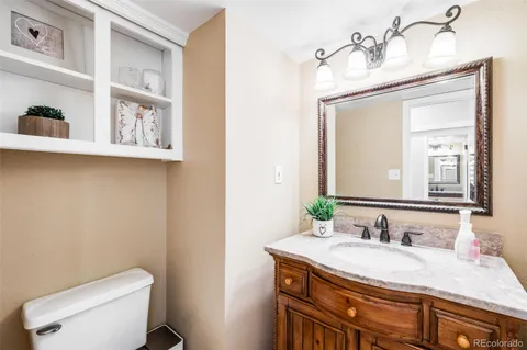 a bathroom with a granite countertop toilet sink and mirror