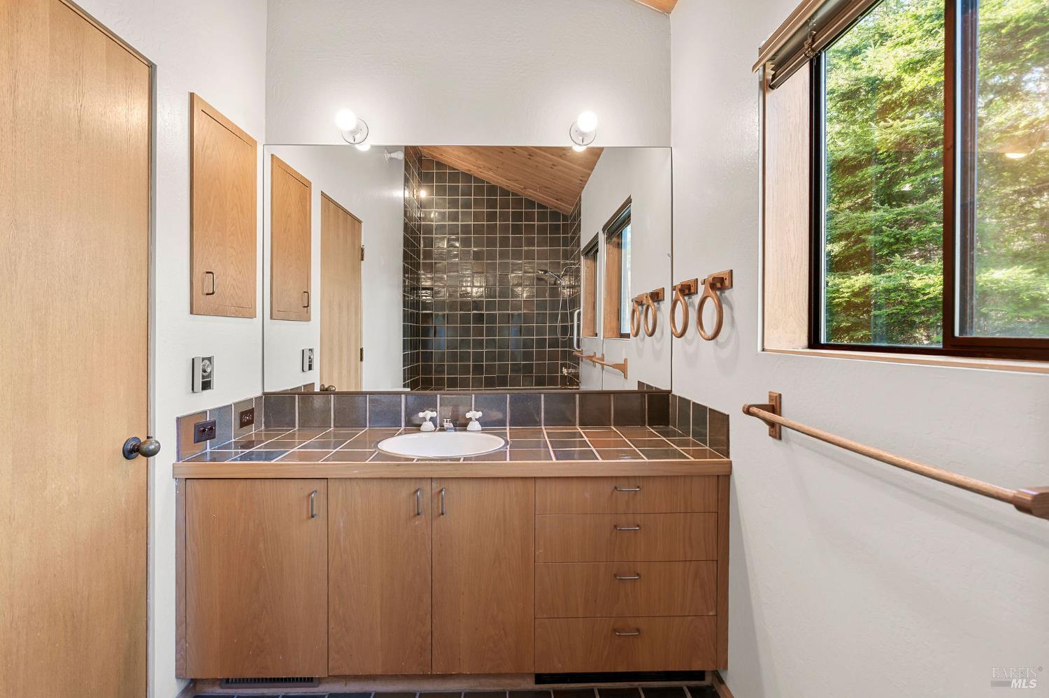 36029 Timber Ridge Road The Sea Ranch, CA 95497 - Photo 29 of 59 a bathroom with a granite countertop sink and a large mirror