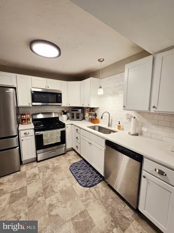 a kitchen with granite countertop a sink stainless steel appliances and cabinets