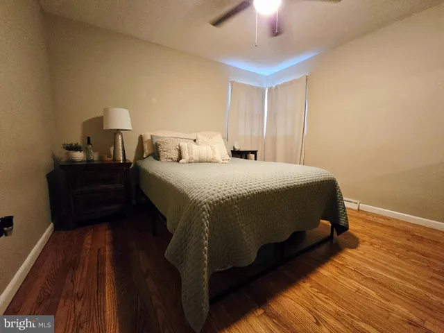 a bedroom with a bed and a lamp on dresser