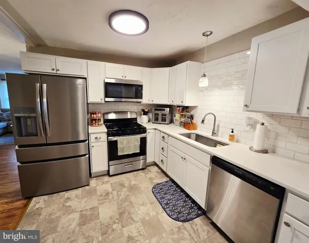 a kitchen with a sink a refrigerator a microwave and cabinets