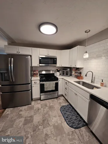 a kitchen with a sink stainless steel appliances and cabinets