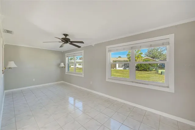 a view of a house with a big yard potted plants and a large tree