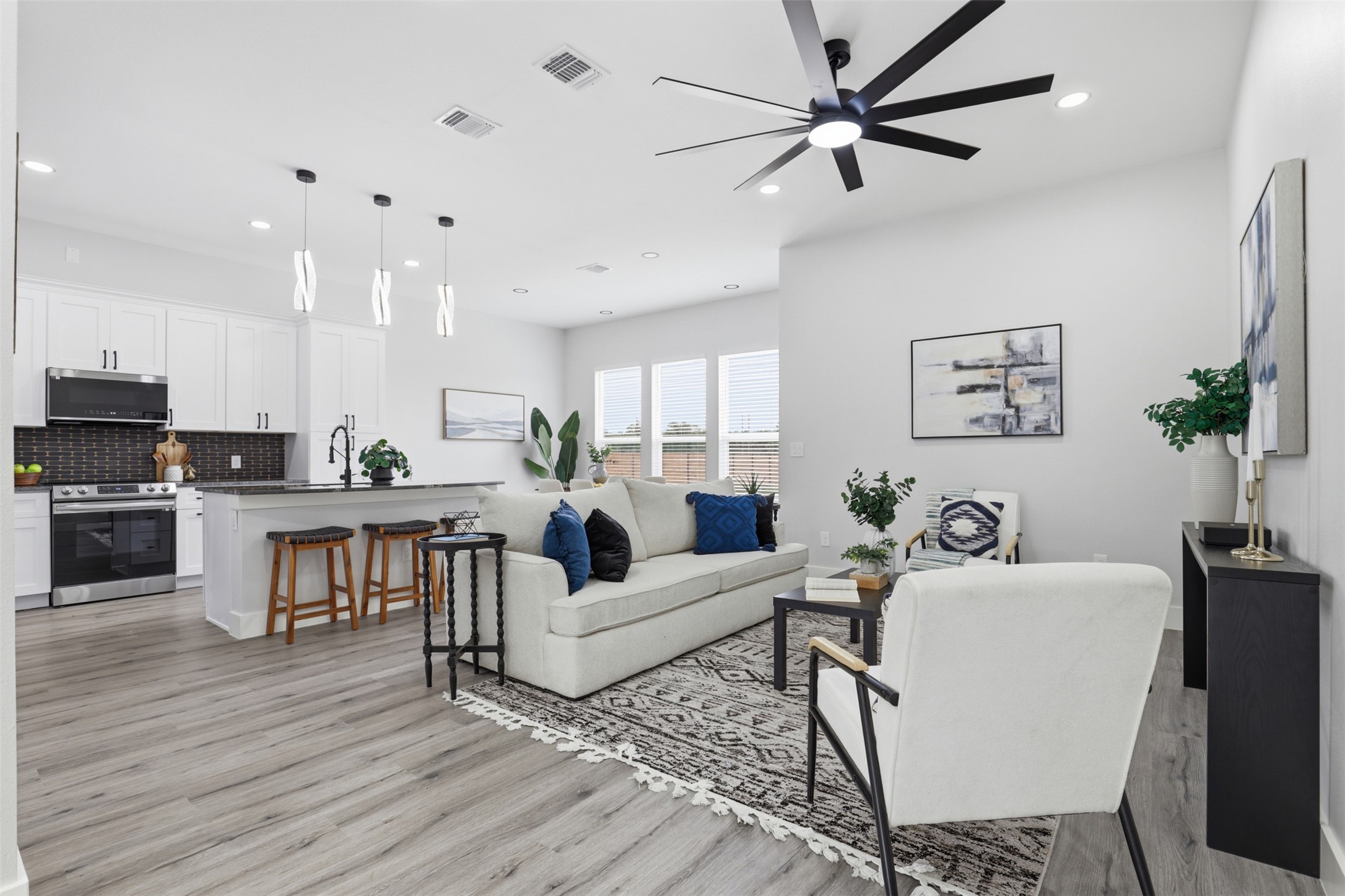 123 Los Robles Road Elgin, TX 78621 - Photo 3 of 21 Open-concept living space featuring wood-finish flooring, recessed lighting, and a contemporary ceiling fan