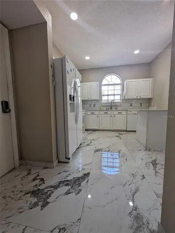 a room with a refrigerator and a stove top oven