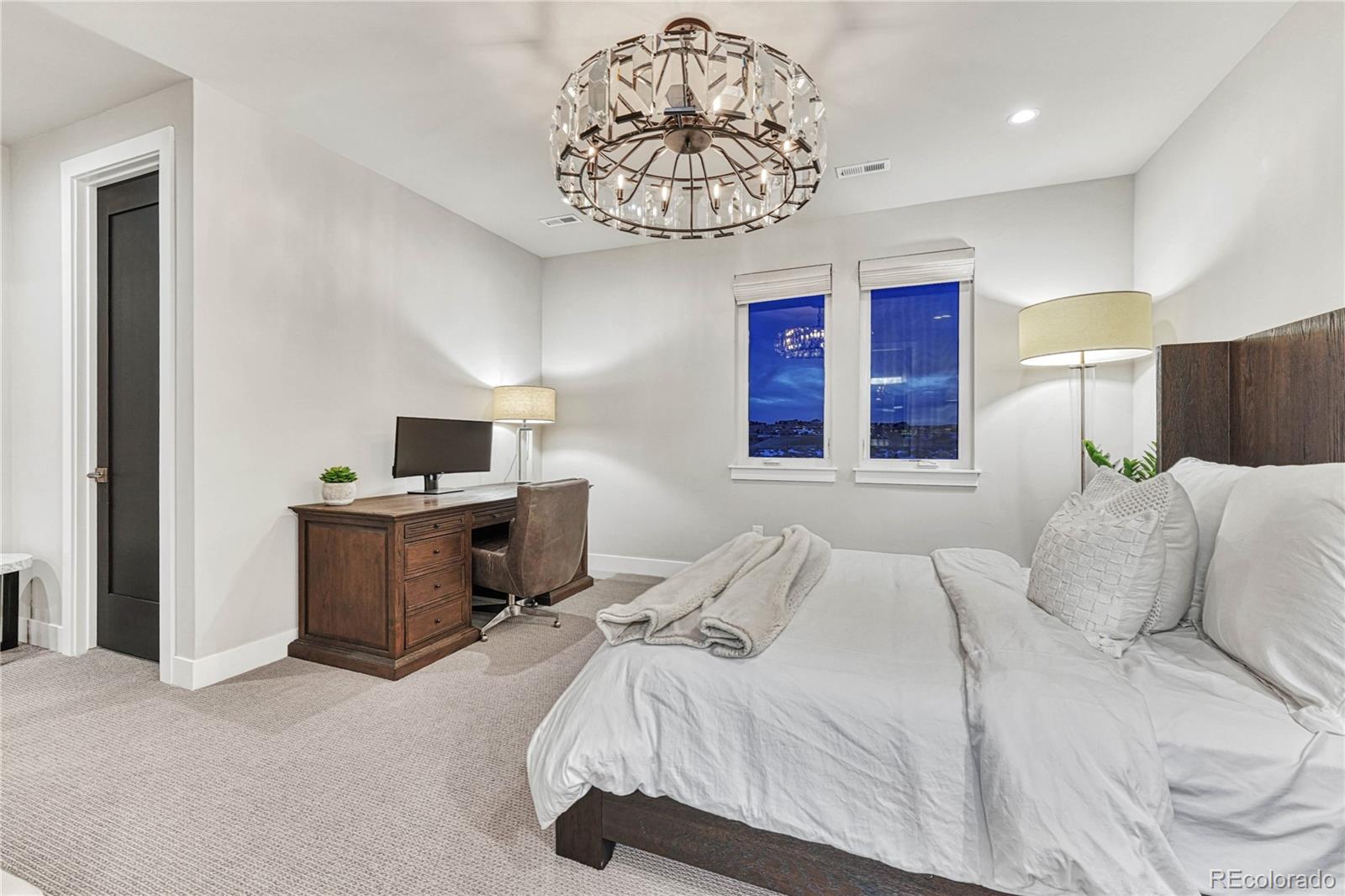 5151 Raintree Circle Parker, CO 80134 - Photo 25 of 50 a bedroom with a bed and a chandelier