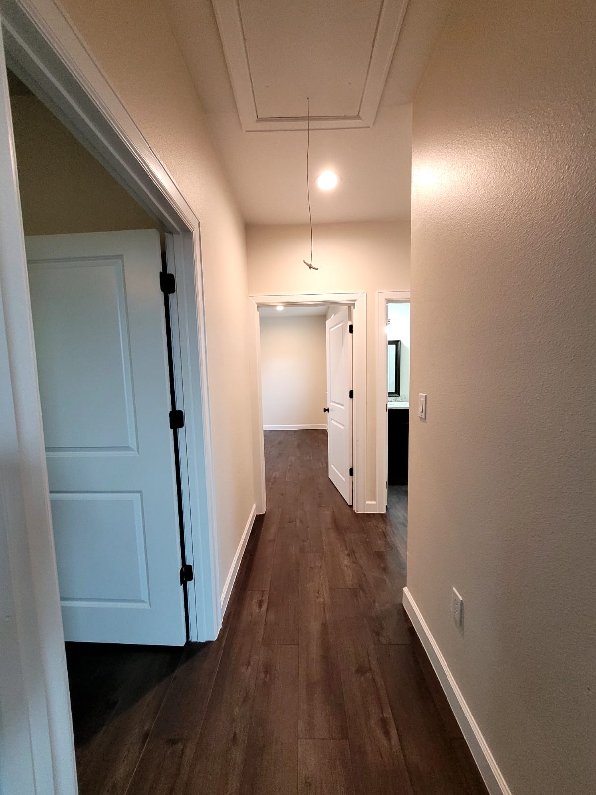 750 South Main Street Lockhart, TX 78644 - Photo 15 of 31 Hallway with dark wood-style floors and attic access