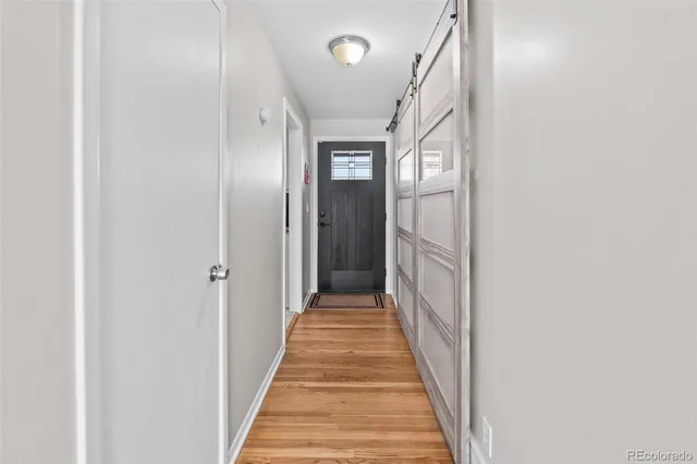 a view of a hallway with wooden floor and entryway