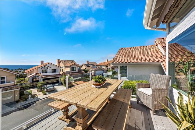 a view of a roof deck with dining table and chairs with wooden floor