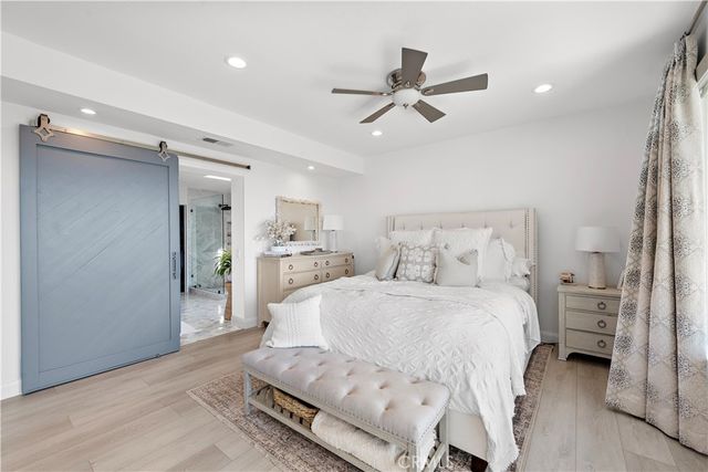 a spacious bedroom with a bed and a chandelier