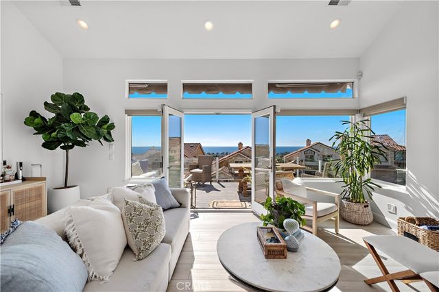 a living room with furniture potted plant and white walls