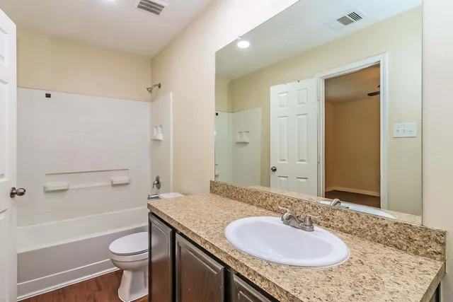 a bathroom with a granite countertop sink toilet and shower