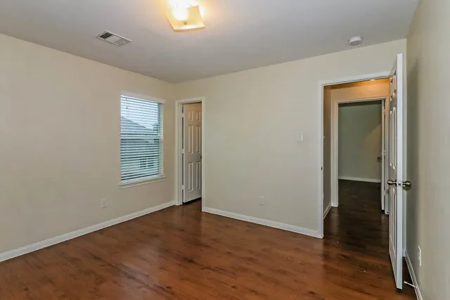 an empty room with wooden floor and a window