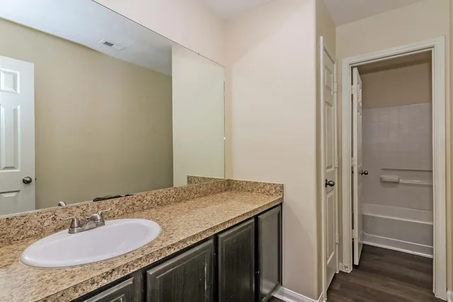 a bathroom with a granite countertop sink and a mirror