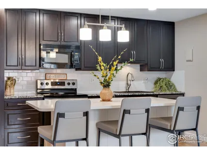 a kitchen with stainless steel appliances kitchen island granite countertop a stove a sink and a cabinets