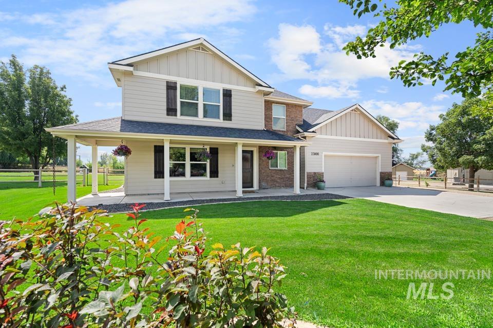 23800 Breyer Road Caldwell, ID 83607 - Photo 45 of 50 Two-story residence featuring light-colored siding, dark shutters, and a covered porch with white columns