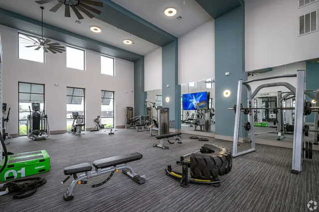 a room with gym equipment pool table and chairs