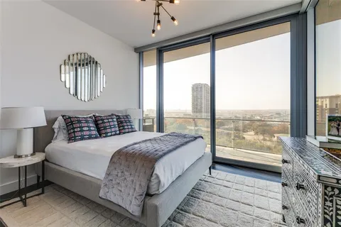 a living room with furniture a flat screen tv and a floor to ceiling window
