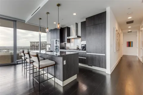 a kitchen with stainless steel appliances granite countertop a sink a stove and a wooden floors