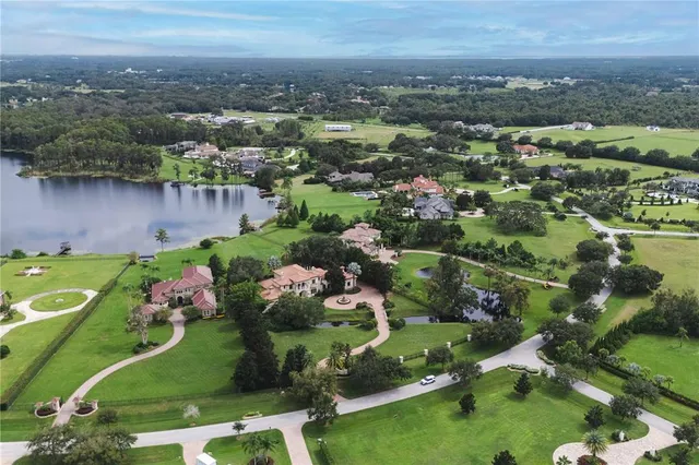 an aerial view of a house with a garden and lake view