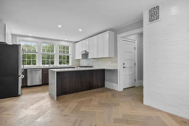 a kitchen with granite countertop a refrigerator and cabinets