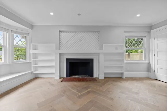 a view of an empty room with window and fire place