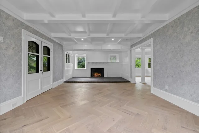 en empty room with windows and fireplace