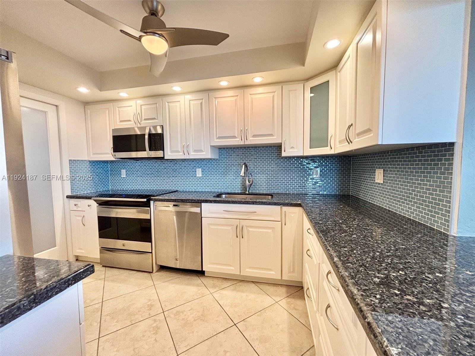 9273 Collins Avenue, Unit 705 Surfside, FL 33154 - Photo 11 of 40 a kitchen with stainless steel appliances granite countertop a stove and a sink