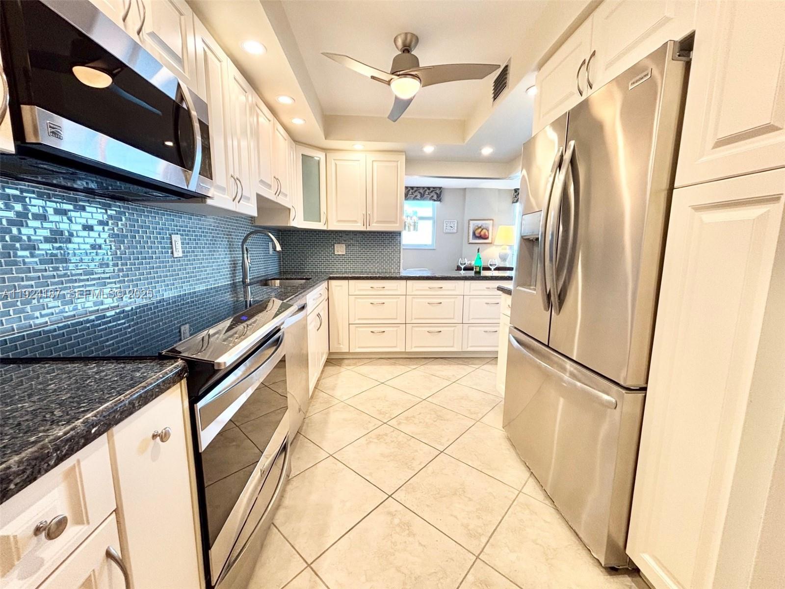 9273 Collins Avenue, Unit 705 Surfside, FL 33154 - Photo 12 of 40 a kitchen with stainless steel appliances granite countertop a refrigerator a sink and a stove