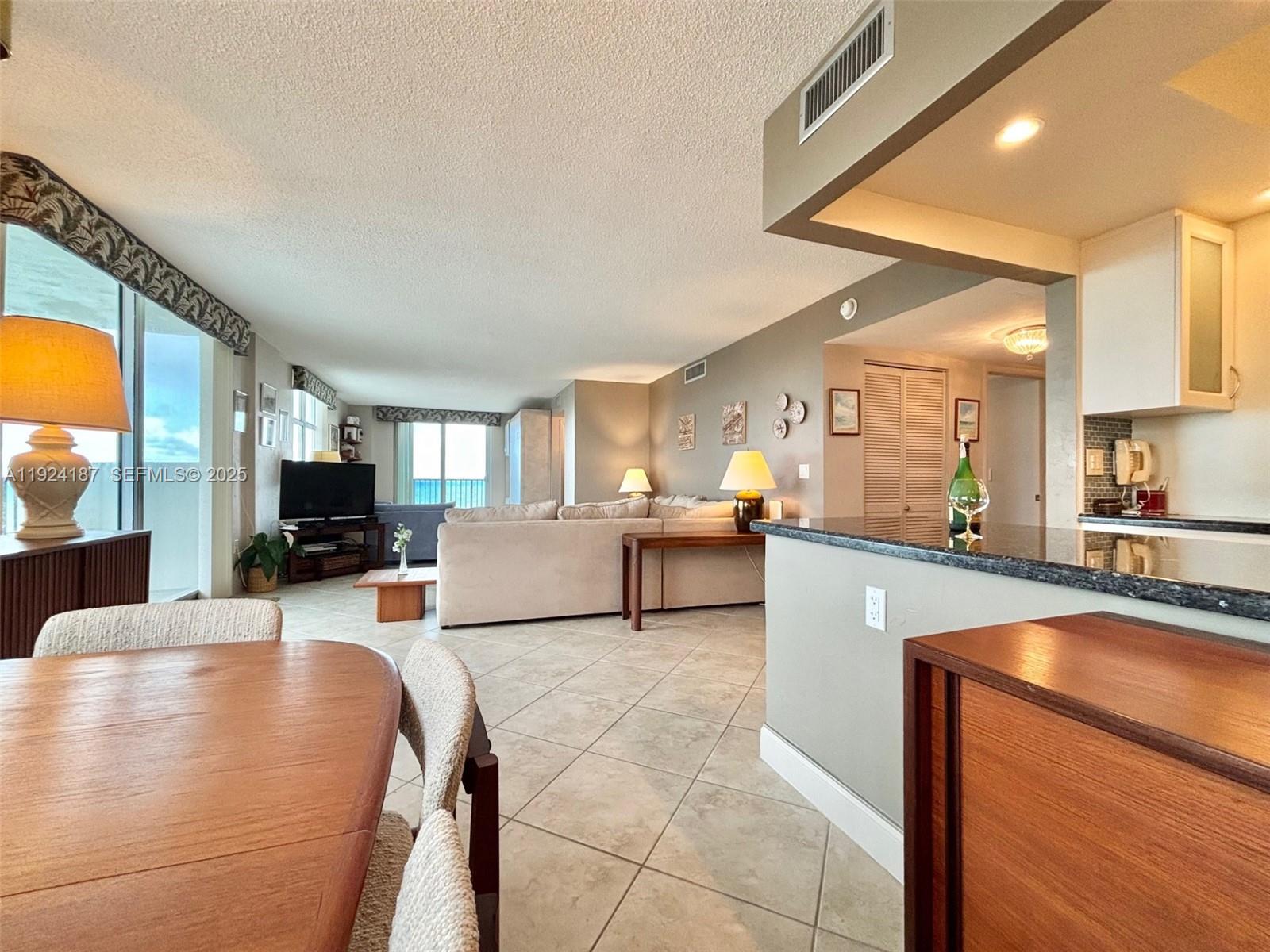 9273 Collins Avenue, Unit 705 Surfside, FL 33154 - Photo 15 of 40 a living room with furniture and a flat screen tv