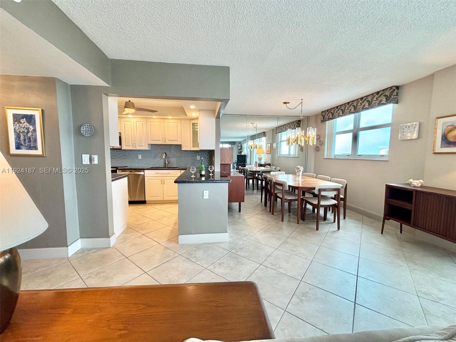 9273 Collins Avenue, Unit 705 Surfside, FL 33154 - Photo 17 of 40 a large dining hall with stainless steel appliances granite countertop a rug and a large window
