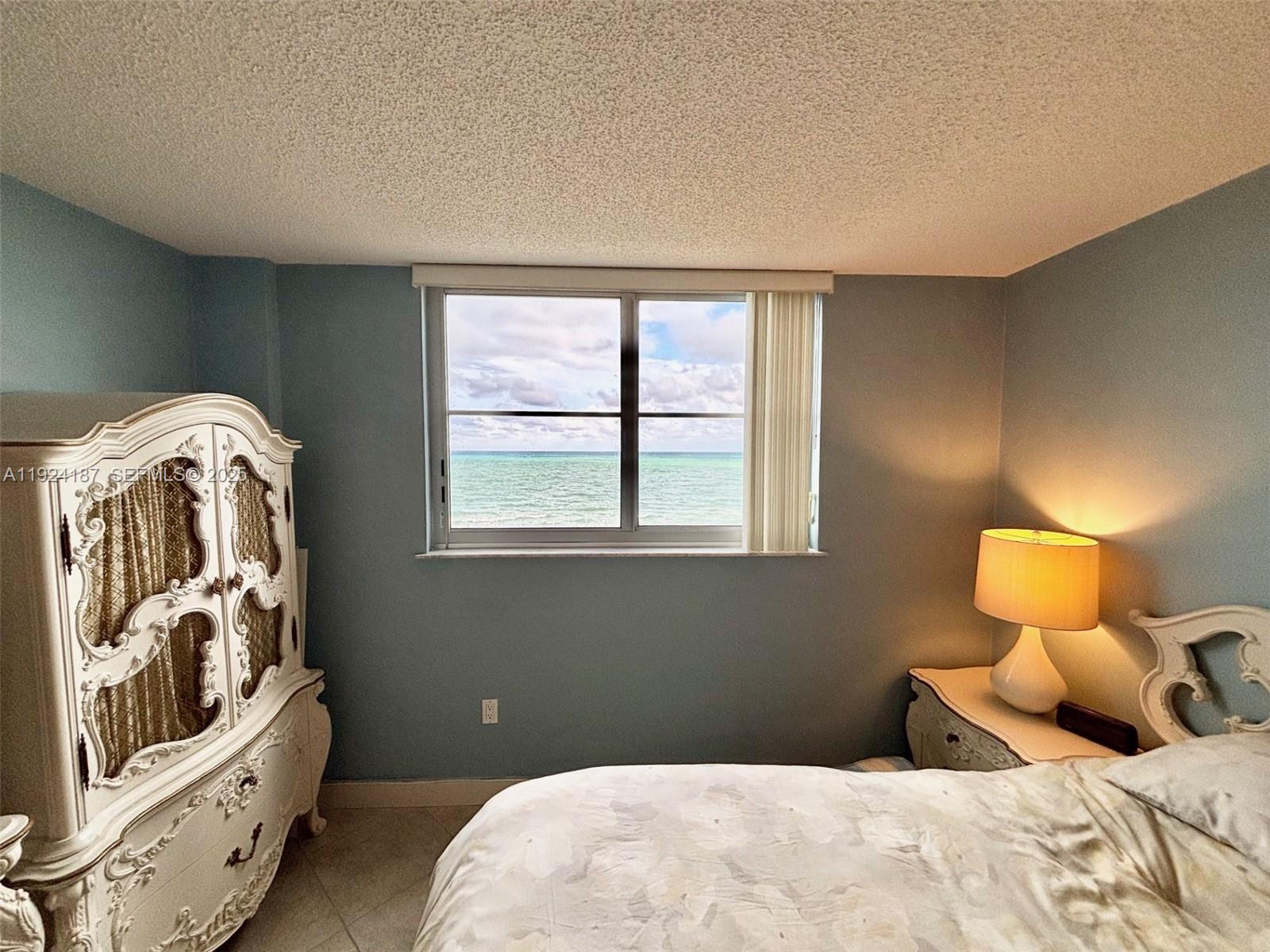 9273 Collins Avenue, Unit 705 Surfside, FL 33154 - Photo 31 of 40 a bedroom with a bed and a window