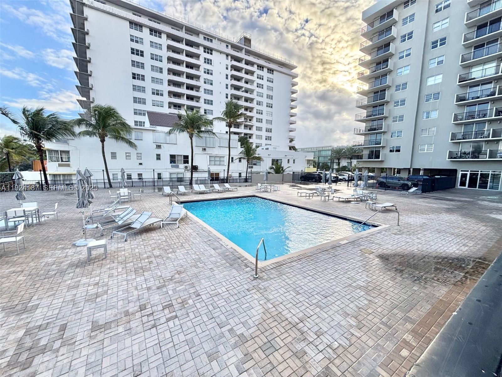 9273 Collins Avenue, Unit 705 Surfside, FL 33154 - Photo 39 of 40 a view of a swimming pool with chairs